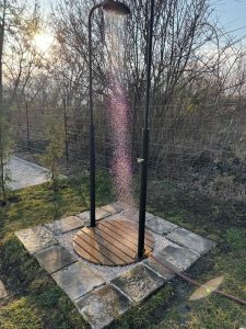 Kültéri zuhany a kertben, Szentendrén az Öregvíz Vendégháznál, napfényes környezetben.
